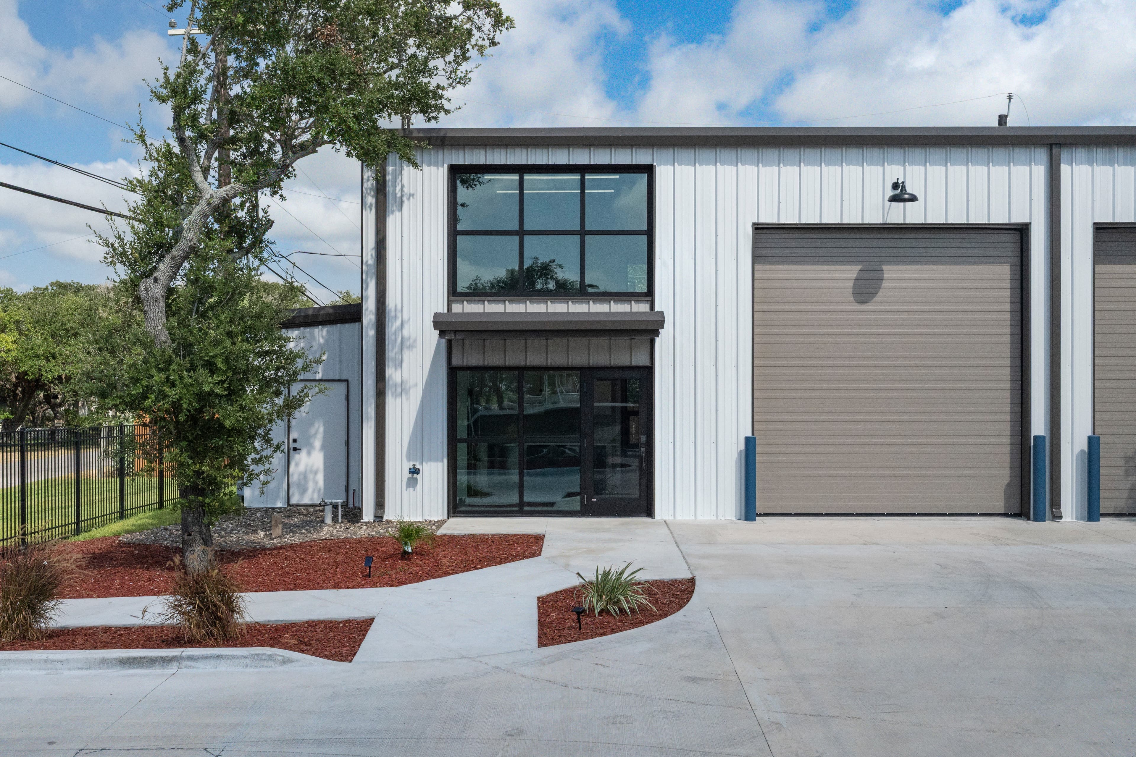 Building exterior in daylight, with the garage door and suite windows