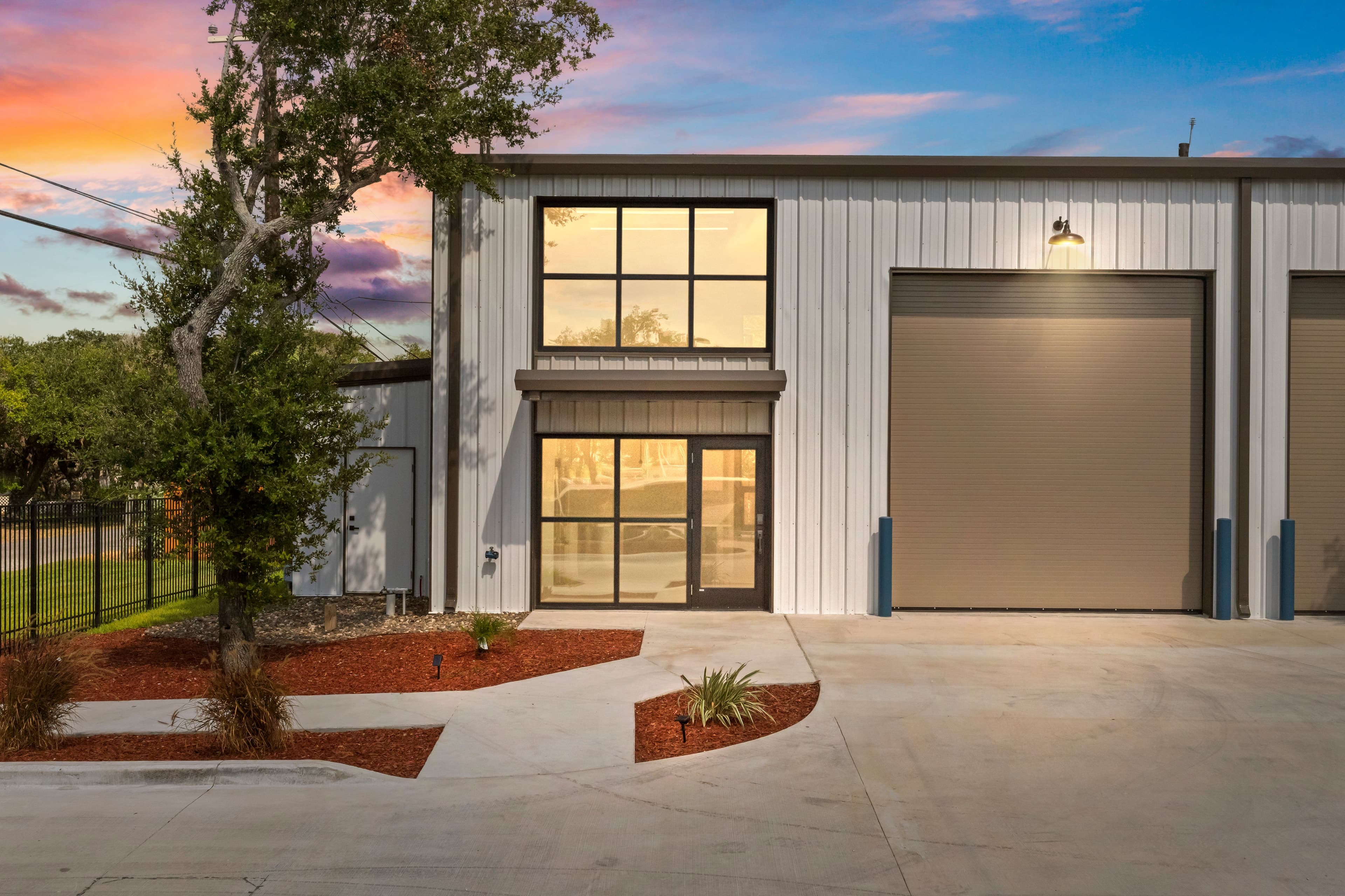 A garage condo at dusk with its windows lit