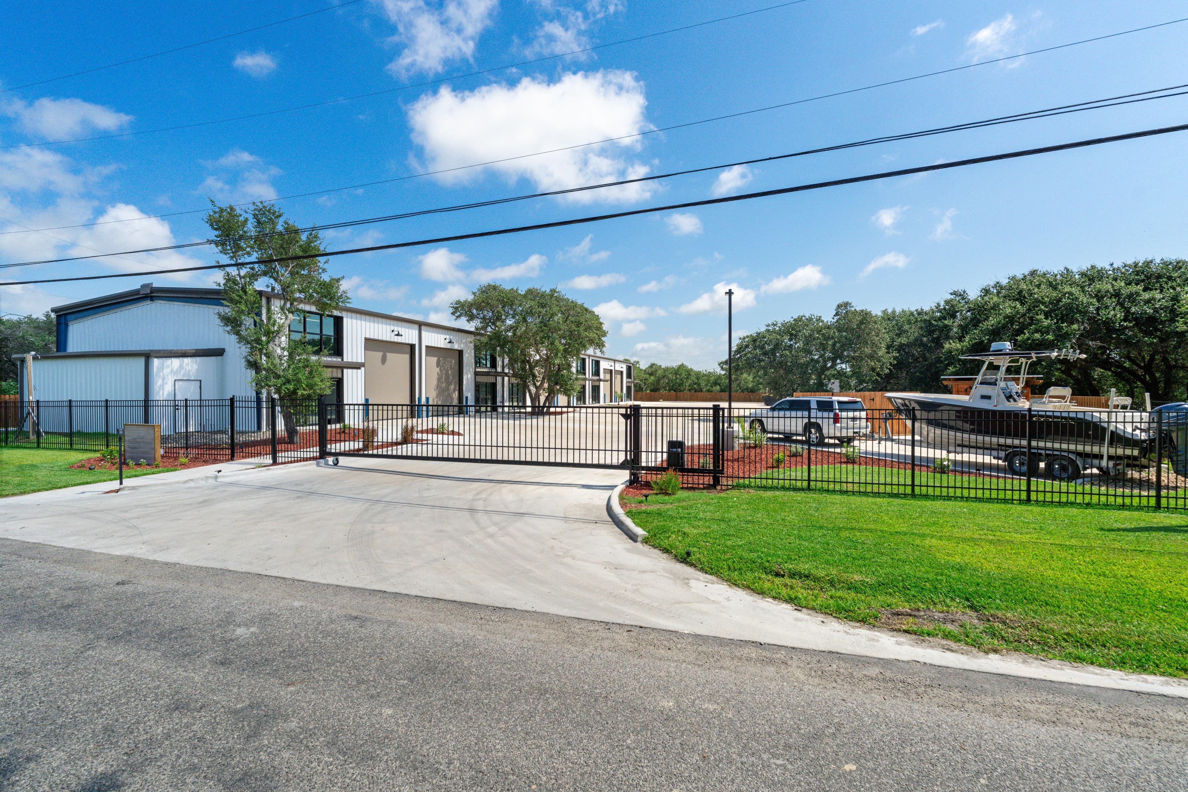 The gated entrance and drive, with a boat parked inside the fence