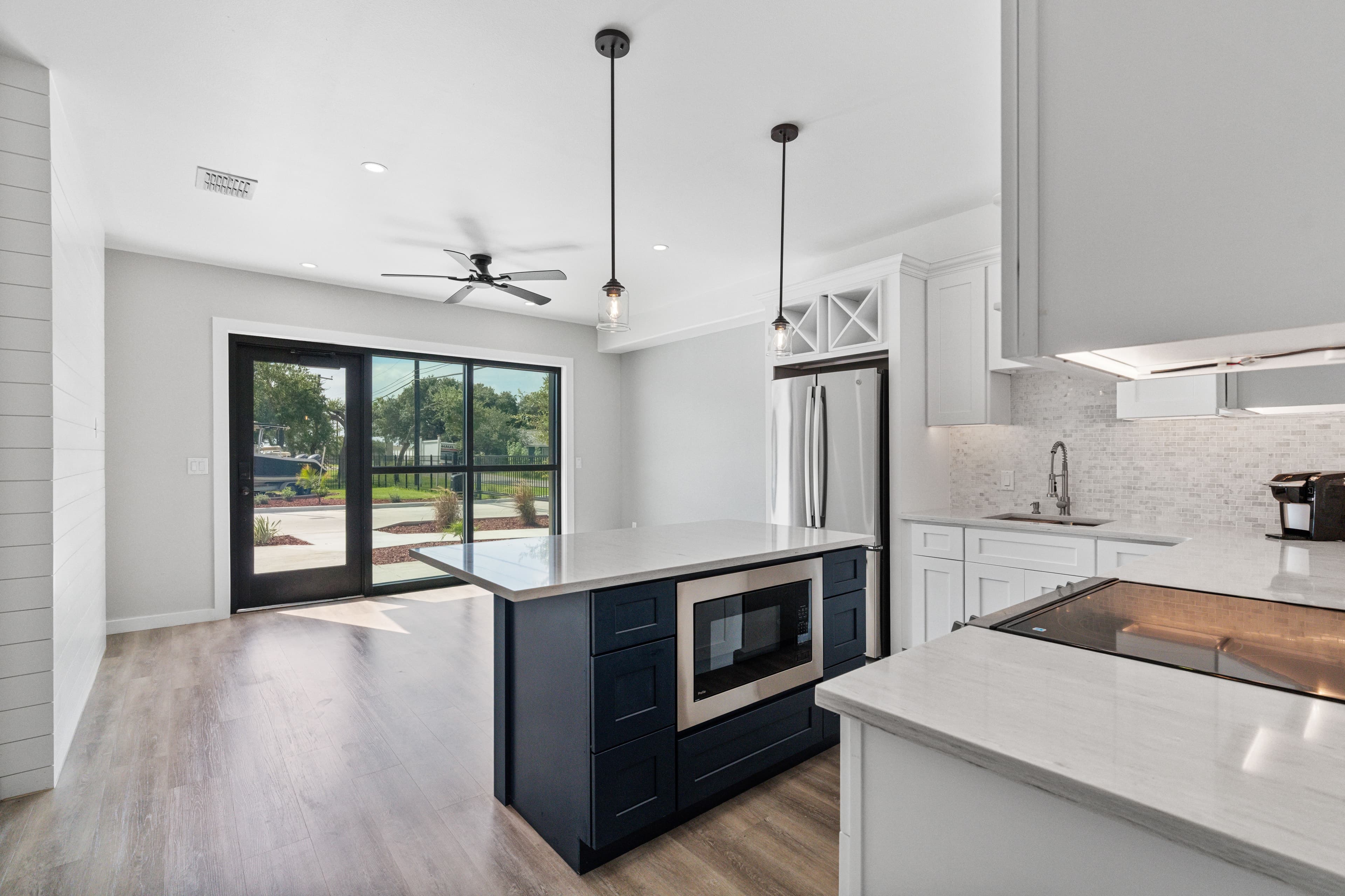 Kitchen island with a black-framed sliding glass door behind